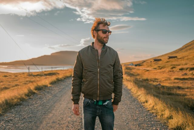 serious man standing on barren road