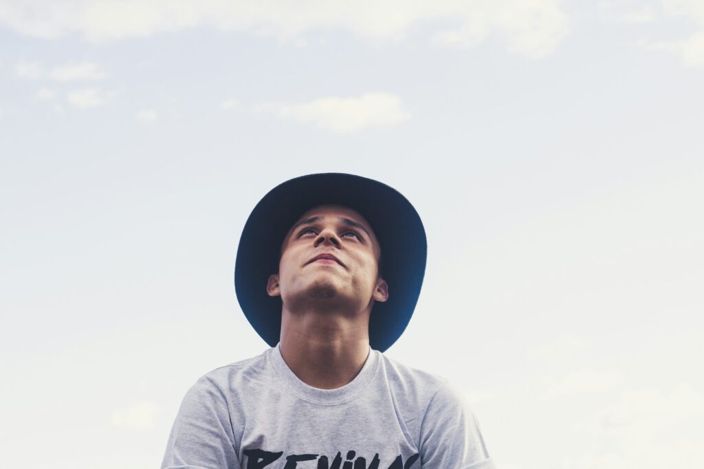 man in hat looking up to sky