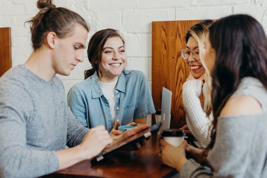 friends sitting together at restaurant table