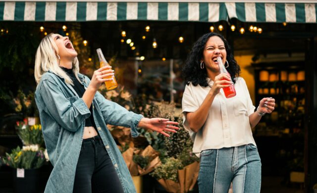 female friends laughing on street