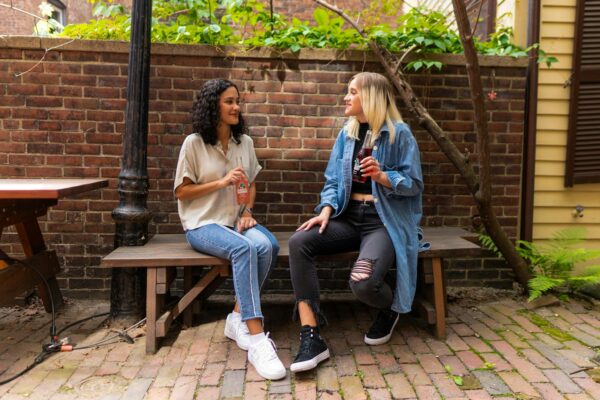 two women chatting on park bench outdoors