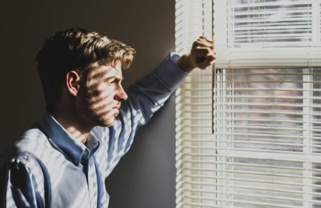 serious man looking out window