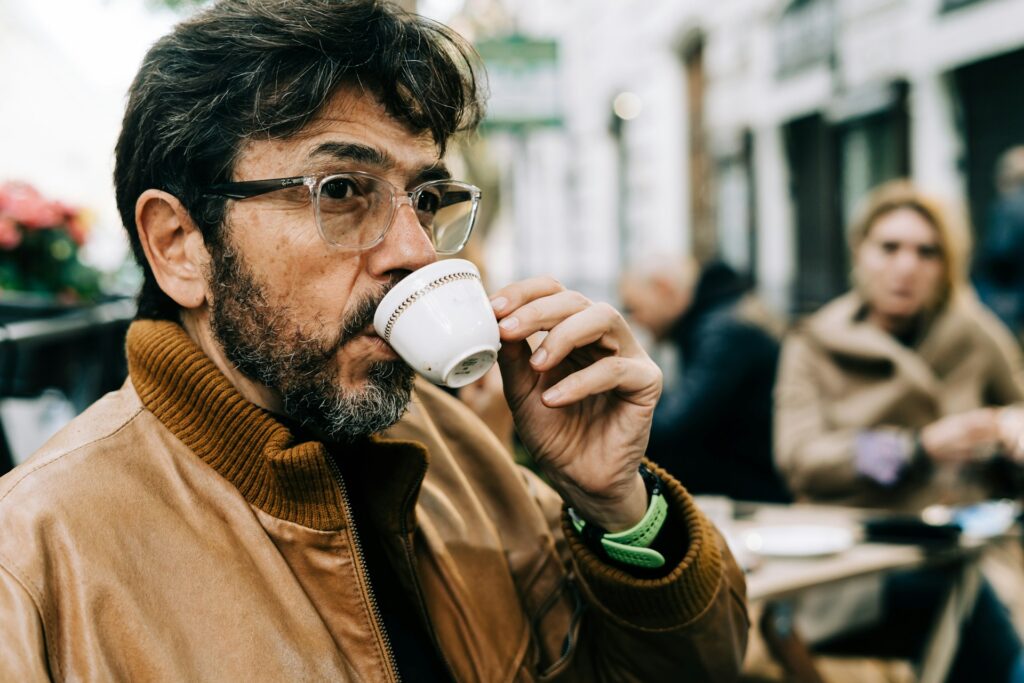 man drinking coffee outdoor cafe